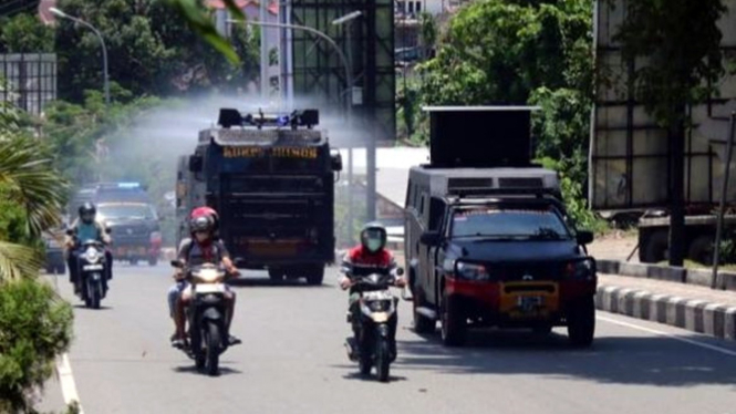 Mobil water cannon menyemprotkan cairan disinfektan