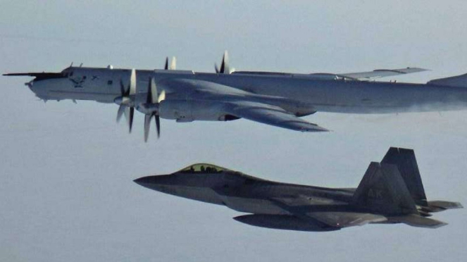 VIVA Militer: Jet Siluman AS F-22 (bawah) mengawal pesawat intai Rusia Tu-142