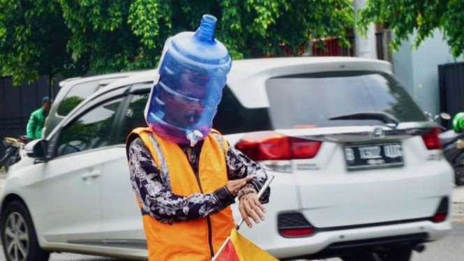 Pengatur lalu lintas di Yogyakarta memakai galon sebagai APD.