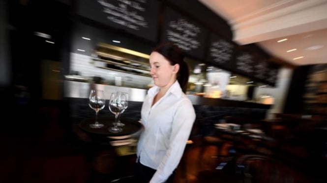 A waitress is seen setting up a table at a restaurant in Canberra, on Thursday, February 23, 2017. The Fair Work Commission announced cuts to Sunday and public holiday penalty rated in the retail and hospitality industries.Â 