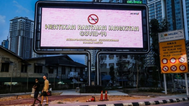 Sebuah papan iklan di Malaysia, yang menampilkan pesan tentang bahayanya Corona.