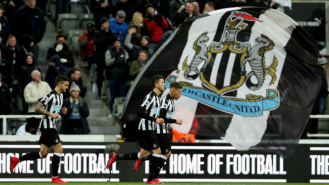 Para pemain Newcastle United berlari di depan bendera