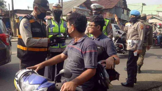 Polisi beri sanksi pelanggar PSBB di Kabupaten Bogor baca Alquran.