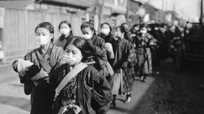 Para siswi di Jepang menggunakan masker dalam perjalanan ke sekolah pada tahun 1920.-Getty Images