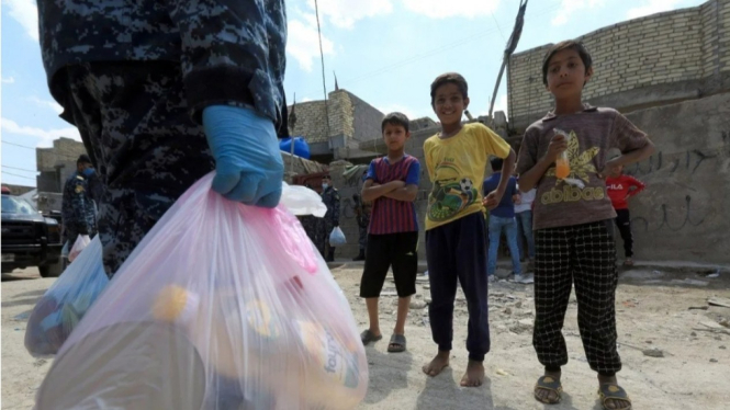 Pasukan Keamanan Irak sedang membagikan makanan ke warga yang terdampak COVID-19