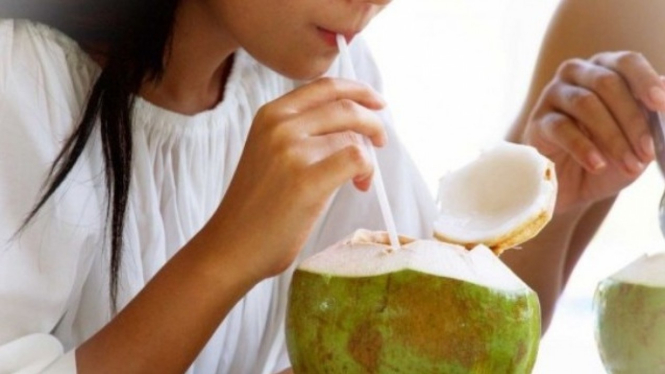 Minum air kelapa muda.