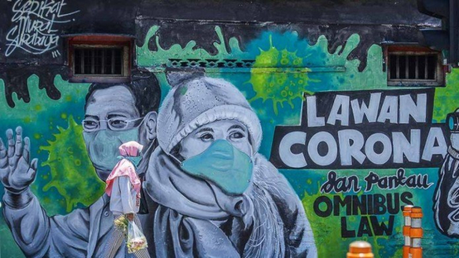 Warga melintas di depan mural Lawan Corona di Jalan Wonokromo, Surabaya, Jawa Timur.