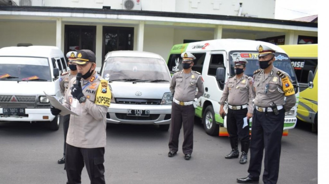 Polisi saat mengamankan mobil travel yang membawa pemudik dari madura