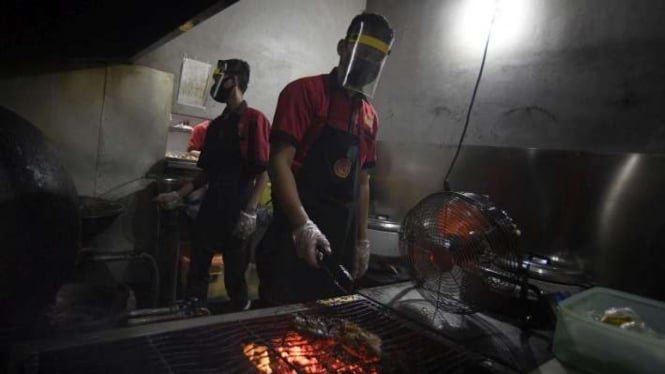 Karyawan mengenakan face shield saat mempersiapkan pesanan makanan di restoran (ilustrasi)