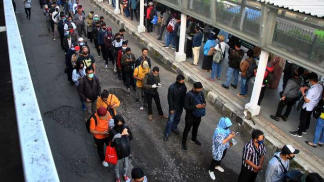 Ratusan calon penumpang KRL Commuter Line mengantre menuju pintu masuk Stasiun Bogor di Jawa Barat, Senin (8/6/2020). 