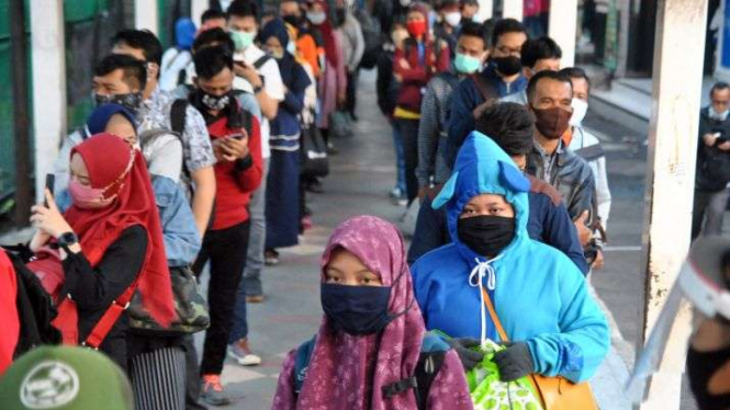 Ratusan calon penumpang KRL Commuter Line antre ke pintu masuk Stasiun Bogor