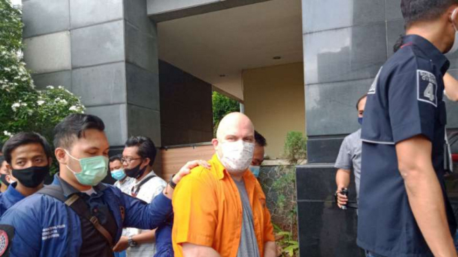 Petugas Polda Metro Jaya membekuk buron FBI (baju oranye).