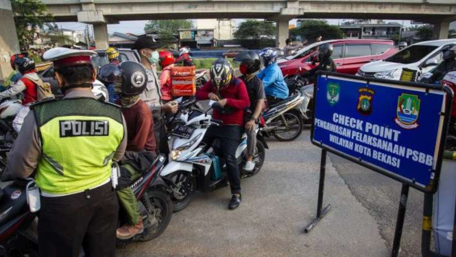 Petugas melakukan pengawasan terhadap kendaraan yang melintasi Check Point Pembatasan Sosial Berskala Besar (PSBB) di kawasan Kalimalang, Bekasi, Jawa Barat, Rabu (13/5/2020). 