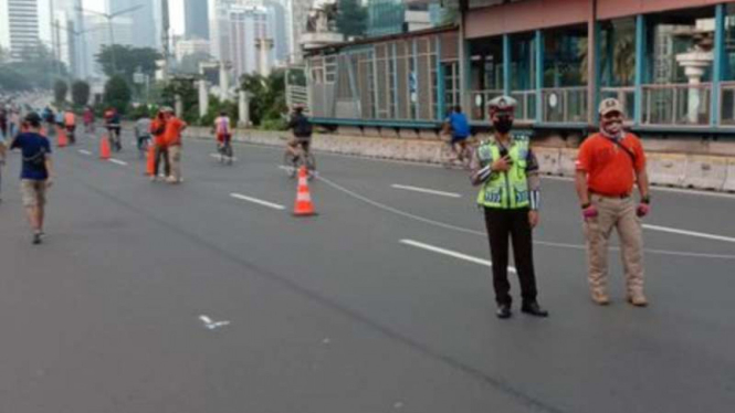Seorang polisi bersiaga di area kegiatan Hari Bebas Kendaraan Bermotor alias Car Free Day (CFD) di Jalan MH Thamrin dan Jalan Sudirman, Jakarta Pusat.