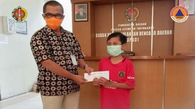 Pelajar SD di DIY bernama Fahmi menyerahkan sumbangan untuk penanganan Corona