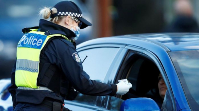 Polisi memeriksa surat izin mengemudi di pinggiran kota di Broadmeadows, di Melbourne, Kamis, 2 Juli 2020.