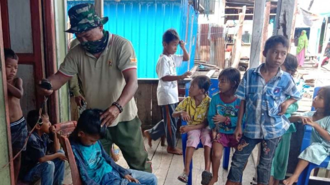 VIVA Militer : Seorang prajurit TNI mendadak jadi tukang cukur di lokasi TMMD 