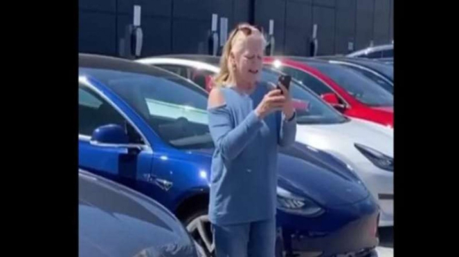 Wanita yang ingin memarkirkan kendarannya di area parkir mobil listrik