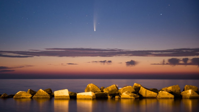 Komet Neowise, tampak di atas Pelabuhan Molfetta, Italia. Lintasan terdekatnya dengan Bumi akan terjadi pada 23 Juli.-Getty Images

