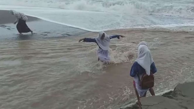 Pelajar menyeberangi sungai Uli berarus deras di Maluku.