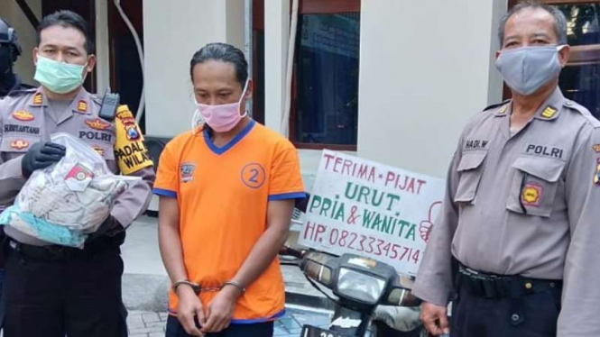 Tukang pijat yang menjadi tersangka pencabulan, berinisial DP (berkaus tahanan oranye), di Markas Polsek Sukolilo Surabaya, Jawa Timur, pada Kamis, 23 Juli 2020.