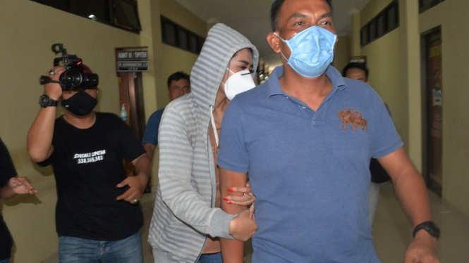 Personel kepolisian membawa artis berinisial VS (tengah) saat akan menjalani pemeriksaan di Polresta Bandar Lampung, Lampung, Rabu (29/7/2020). 