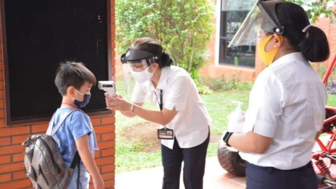 Seorang pelajar sekolah dasar di Tangerang, Banten, diperiksa subuh tubuhnya sebelum memasuki kompleks sekolah sebagai salah satu penerapan protokol kesehatan pencegahan penularan COVID-19.