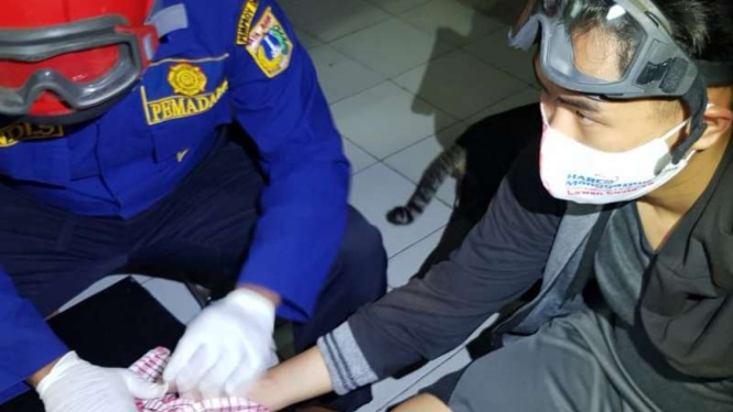 Petugas pemadam kebakaran sektor Cengkareng dalam operasi melepaskan cincin yang melukai tangan seorang remaja pria warga Kelurahan Kapuk, Cengkareng, Jakarta Barat, Sabtu subuh, 8 Agustus 2020.