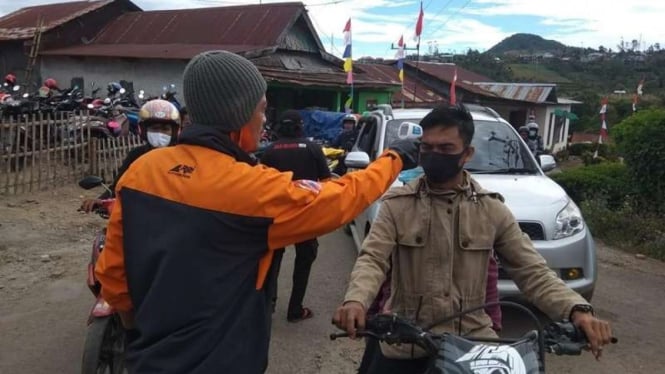 Pengecekan suhu badan sebelum melewati jalur pendakian Gunung Bawakaraeng, Gowa