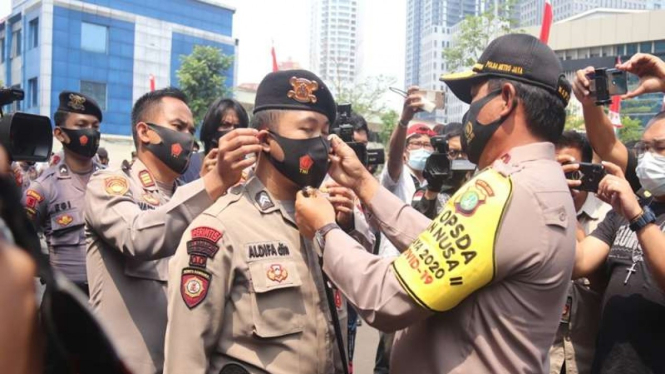 Kapolda Metro Jaya Irjen Nana Sudjana memasangkan masker ke anak buahnya