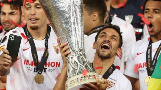 Kapten Sevilla, Jesus Navas mengangkat trofi Liga Europa 2019/20.