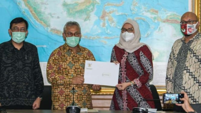 Ketua Komisi Pemilihan Umum (KPU) Arief Budiman (kedua kiri) menyerahkan petikan Keputusan Presiden kepada Komisioner KPU Evi Novida Ginting Manik (kedua kanan) usai memberikan keterangan pers di Kantor KPU, Jakarta, Senin (24/8/2020).