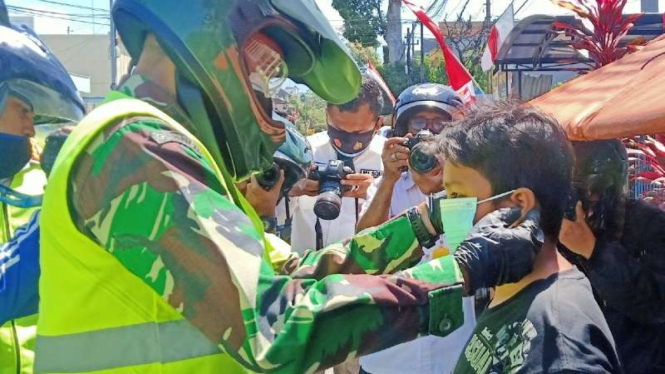 Warga Kota Malang yang terjaring operasi gabungan diberi masker dan disanksi menyapu atau memungut sampah.