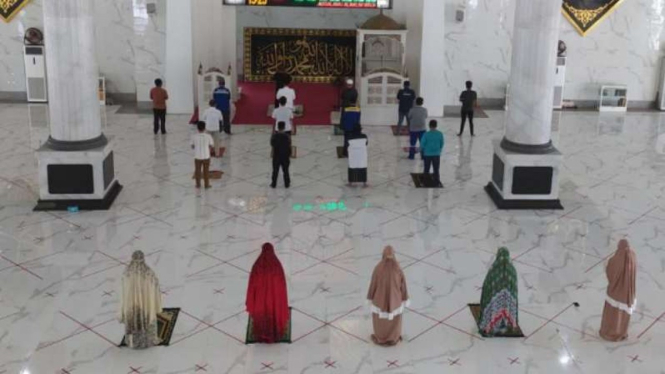 Pelaksanaan ibadah salat dengan menerapkan protokol kesehatan di masjid.