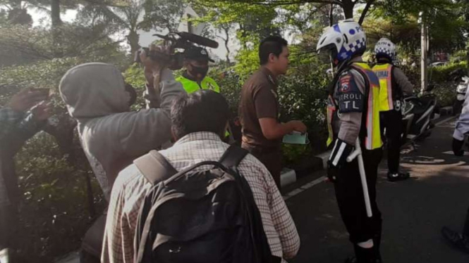 Petugas menegur oknum jaksa yang tidak mengenakan masker saat berkendara di Surabaya, Jawa Timur, pada Senin, 14 September 2020.