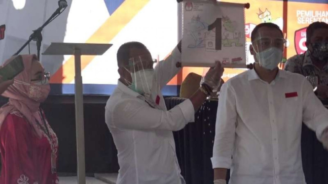 Pasangan calon wali kota dan wakil wali kota Surabaya Eri Cahyadi-Armudji menunjukkan nomor urut untuk mereka di pilkada Surabaya dalam rapat pleno KPU pada Kamis, 24 September 2020.