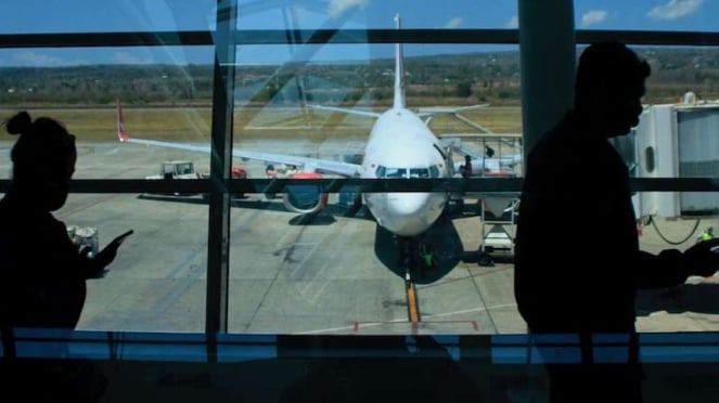 Calon penumpang di bandara berjalan menuju pesawat terbang komersil. (Foto ilustrasi)