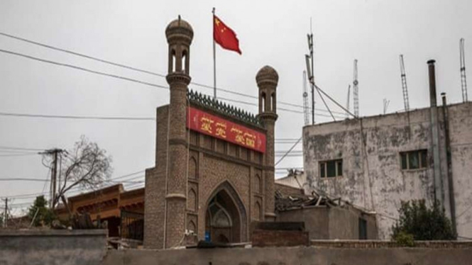 Bendera China berkibar di atas masjid yang sudah ditutup pihak berwenang di Kota Tua Kashga, China.