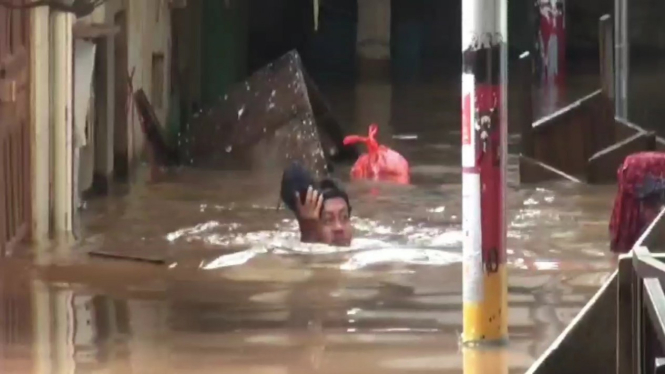 Warga menerjang banjir di Kebon Pala, Jatinegara, Jakarta Timur