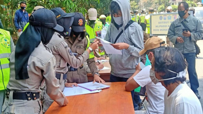 Aparat gabungan dalam operasi yustisi untuk mendisiplinkan warga dalam menerapkan protokol kesehatan pencegahan penularan COVID-19, terutama memakai masker, di Kota Malang, Jawa Timur.