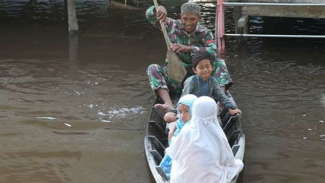 VIVA Militer: Koptu TNI Syahdan Shaleh jemput anak-anak pakai sampan.