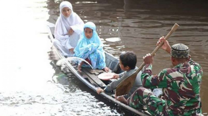 VIVA Militer: Koptu TNI Syahdan Shaleh jemput anak-anak pakai sampan.