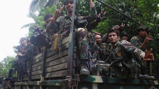 Tentara memberi isyarat di atas truk militer saat mereka dikerahkan ke desa-desa terpencil di Jolo, Sulu, Filipina selatan 17 Oktober 2014.
