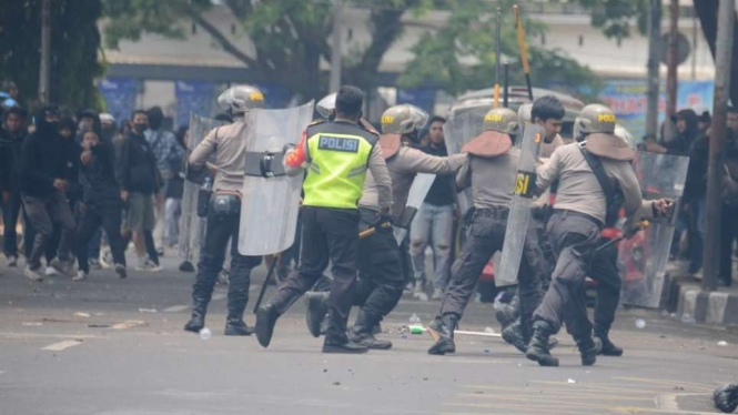 Polisi menangkap seorang demonstran dalam unjuk rasa yang berlangsung ricuh untuk menolak Undang-Undang Omnibus Law Cipta Kerja di Malang, Jawa Timur, pada 8 Oktober 2020.