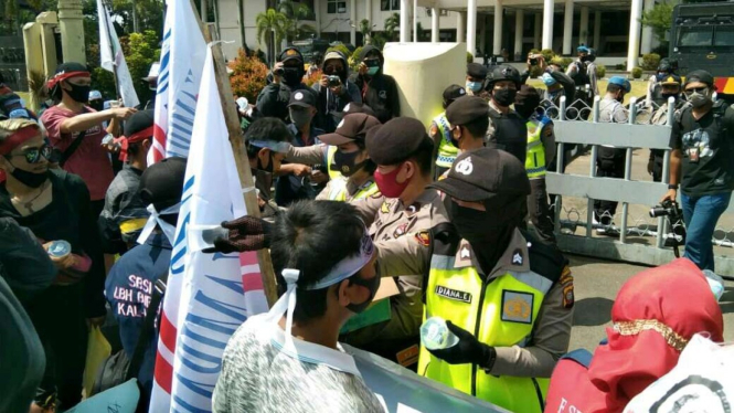 Polwan membagikan air mineral ke pendemo UU Ciptaker di depan DPRD Kalbar