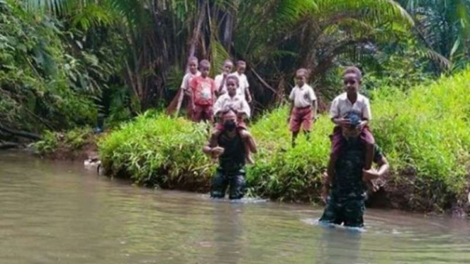 VIVA Militer : Satgas Pamtas RI-PNG membantu anak-anak seberangi Sungai Atakat 