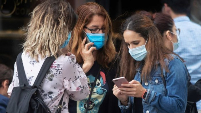 Tiga perempuan memakai masker untuk membantu mencegah penyebaran virus corona di Madrid, Spanyol, Kamis, 8 Oktober 2020.