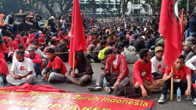 Massa buruh dan mahasiswa yang tergabung dalam Aliansi Malang Melawan berunjuk r
