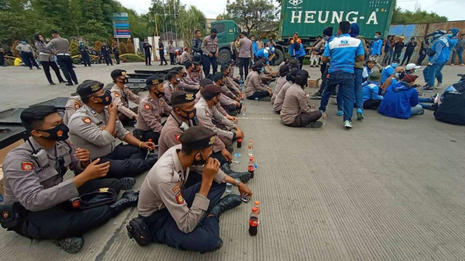 Buruh dan Polisi Berbagi Air Mineral di Gerbang Tol Kota Serang Banten