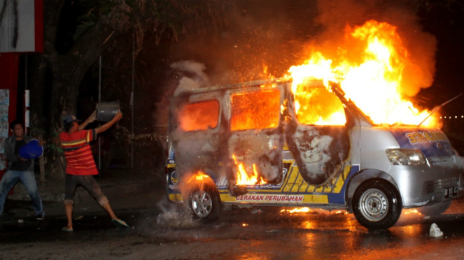 Warga berusaha padamkan ambulans yang dibakar massa pendemo di Makassar